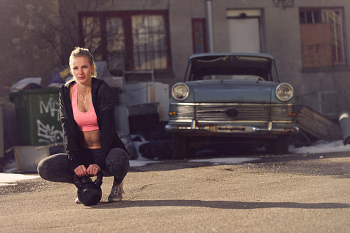 Fitness Woman with Kettlebell on the Street Resting