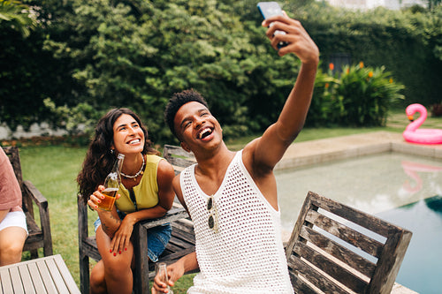 Friends take a selfie at backyard pool party