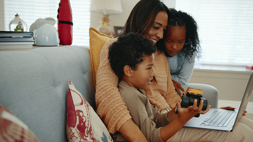 Mom and two kids having a family video call on a laptop