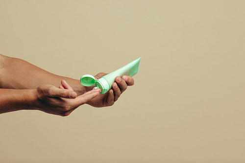 Male hands dispensing a facial mask cream for a skincare routine