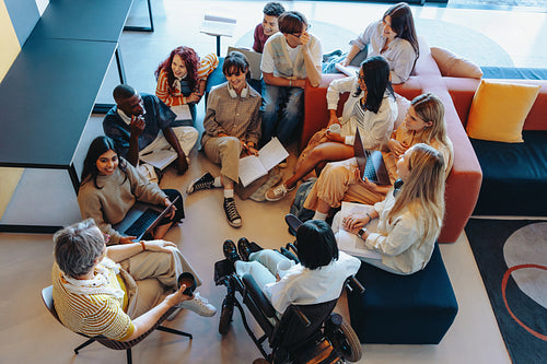Diverse group meeting in a modern library setting, engaging in collaborative discussion and teamwork