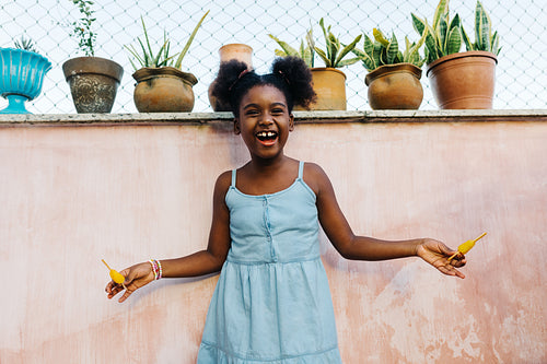 Happy Afro-Brazilian girl enjoying picolés, frozen fruit popsicles