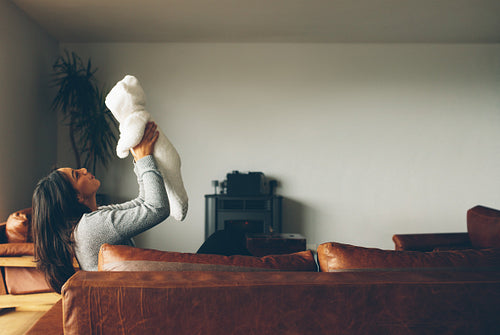 Woman playing with her baby boy at home