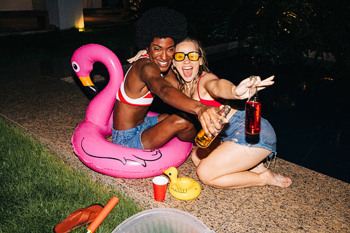 Friends by pool party with flamingo float
