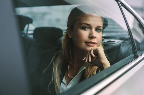 Female executive travelling by a car