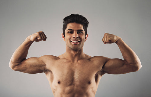 Muscular man pulling his biceps to show off