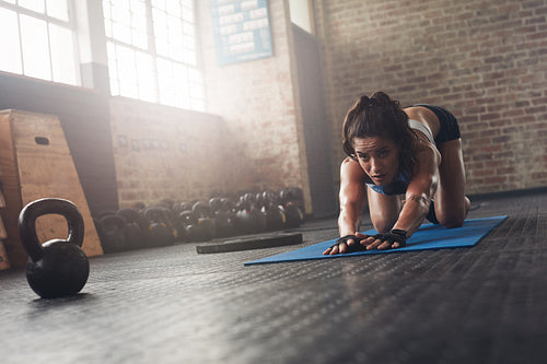  Focused woman stretching on fitness mat