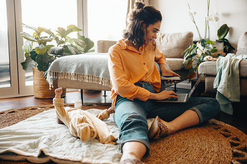 Mother working from home with baby and laptop