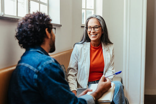 Coworkers having a creative discussion in the office lounge area