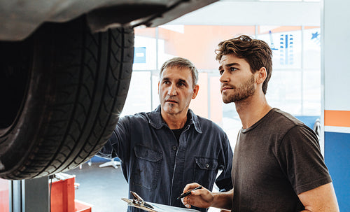 Mechanics inspecting the car in service station