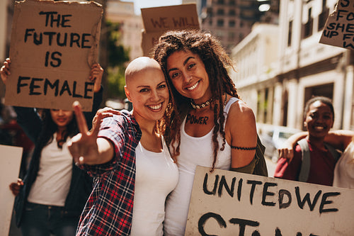 Female activists with placards and peace sign