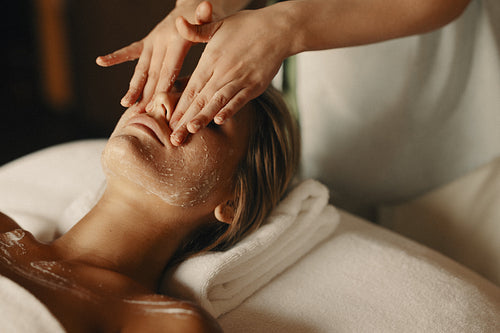 Woman enjoying a relaxing facial treatment at a spa
