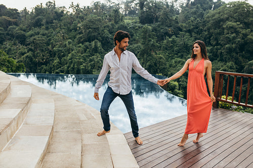 Loving couple walking by pool at the resort