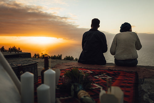 Couple having picnic looking at sunset