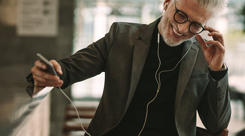 Businessman making phone call using earphones