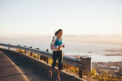 Woman jogging in morning on country road