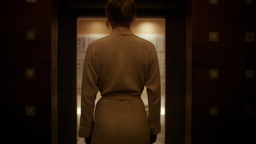 Woman in bathrobe enters a luxurious hammam room ready for a relaxing spa treatment