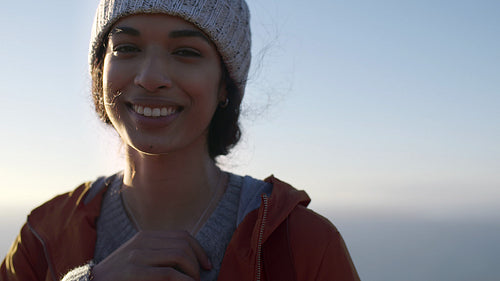 Smiling woman in warm wear standing outdoors on winter day