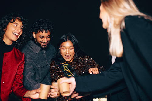 Friends celebrate as the birthday girl pours drinks at night party