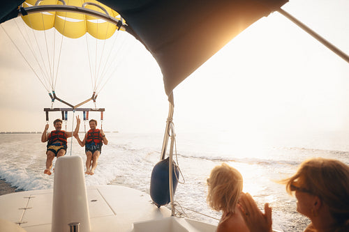 Family enjoying parasailing activity on a sunny day at sea