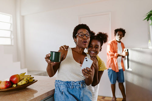 Mother and daughter singing and playing music together at home