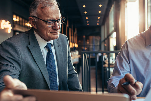 Senior businesspeople working together in a cafe