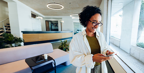 Woman using phone in lobby space