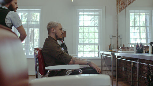 Barber covering client with salon cape