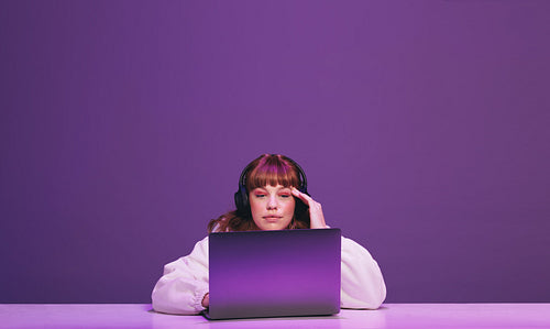 Woman thinking while playing an online video game