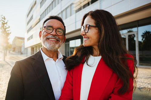 Smiling senior executives standing outdoors in professional attire