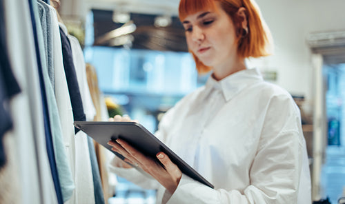 Businesswoman using digital tablet in her clothing store