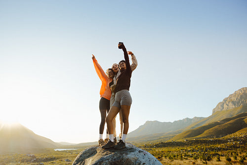 Friends celebrating outdoors on mountain peak