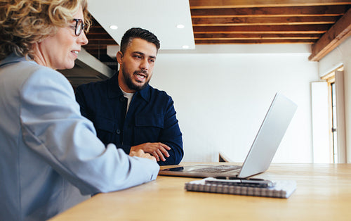 Business man presenting a slideshow to his colleague in an office