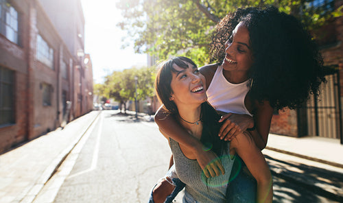 Two young woman having fun on city street