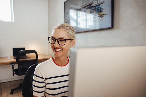 Smiling architect working at a computer in a modern office environment