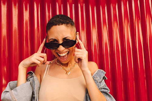 Young woman smiling while wearing sunglasses