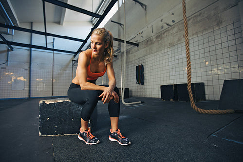 Fit young woman taking break after workout at gym
