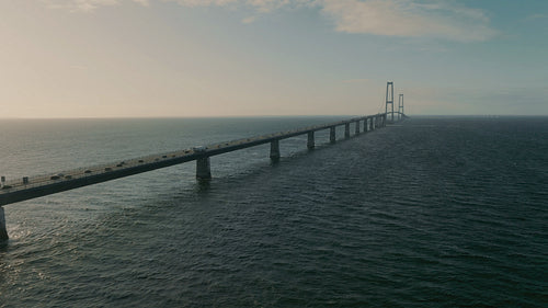 Sunset over the scenic Storebæltsbroen Bridge in Denmark, with traffic moving along the costal roadway