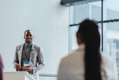 Confident business man presenting at business seminar in modern conference room