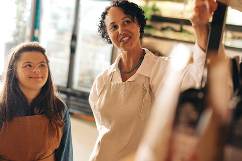 Shop supervisor giving instructions to her new employee in a grocery store
