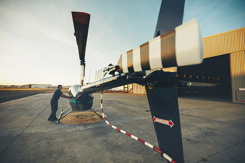 Male pilot inspecting helicopter