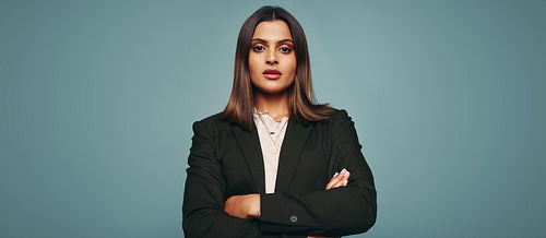 Self-assured young woman standing with her arms crossed