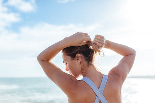 Female athlete tying hair outdoors