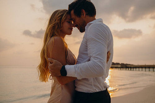 Romantic sunset embrace: Young couple in love on the beach