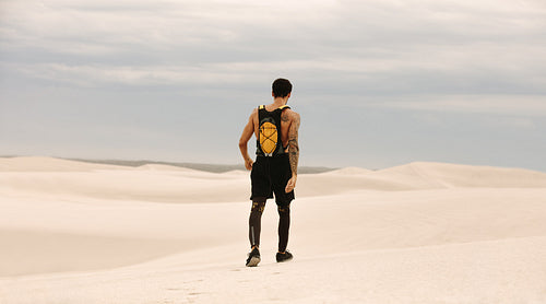Male athlete walking in desert