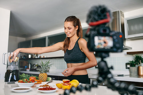 Young female blogger recording content for videoblog in Kitchen.
