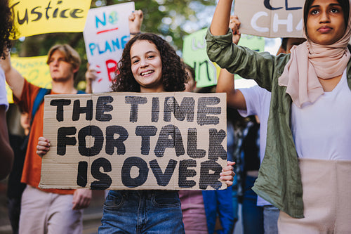 Happy young girl holding a poster during a global climate strike