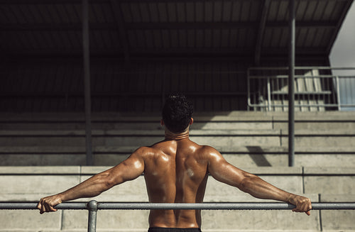 Muscular man resting in stadium stands