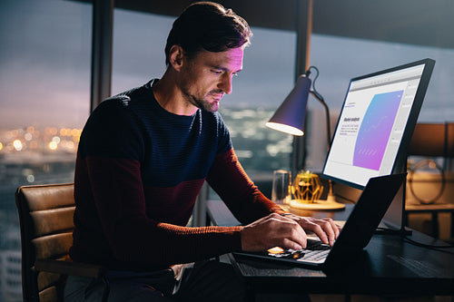 Entrepreneur tackling marketing projects on his laptop at night