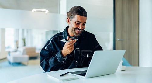 Man uses laptop and pen in tech office